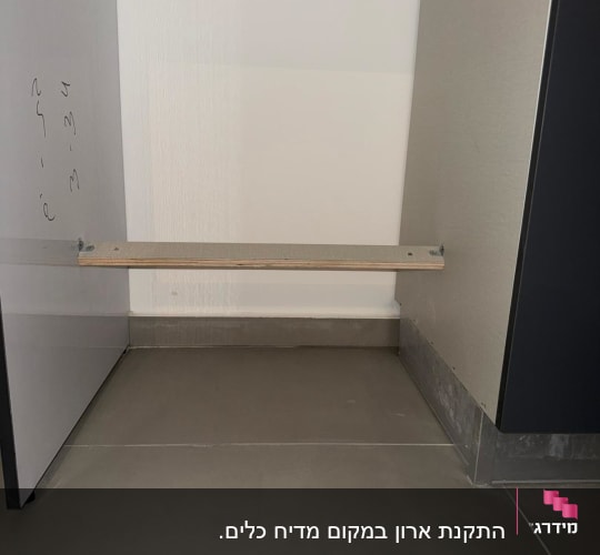 תמונה של ארון מטבח ריק עם מדף עץ